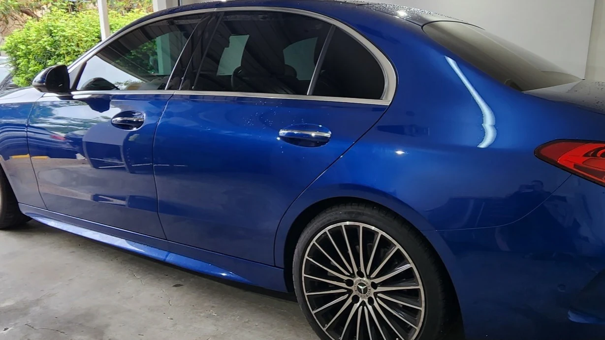Car window tinting in Brisbane on a blue sedan with dark legal window film installed by Glass Tinting Solutions