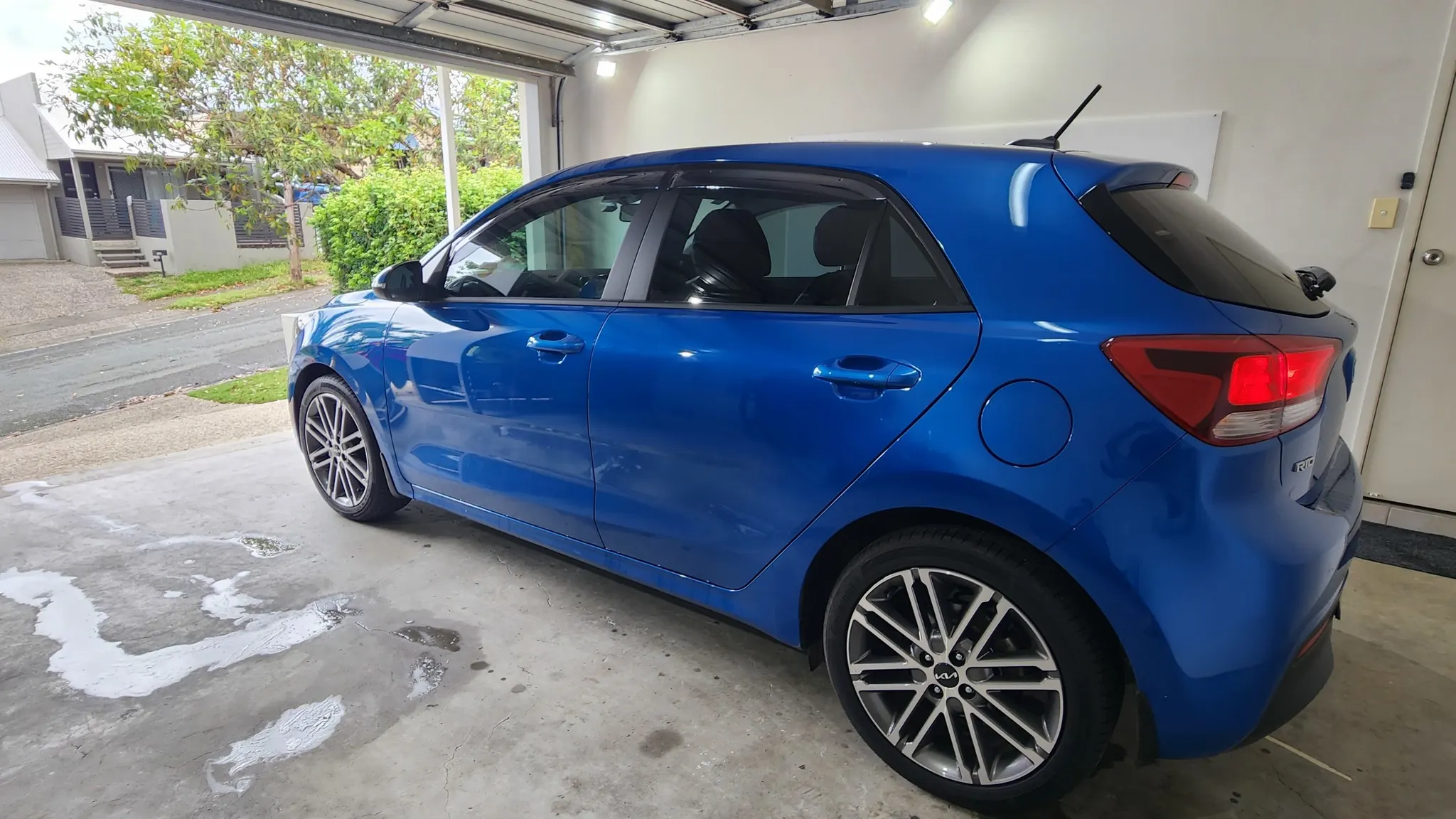 Car window tinting in Brisbane on a blue Kia Rio hatchback with dark window film installed by Glass Tinting Solutions