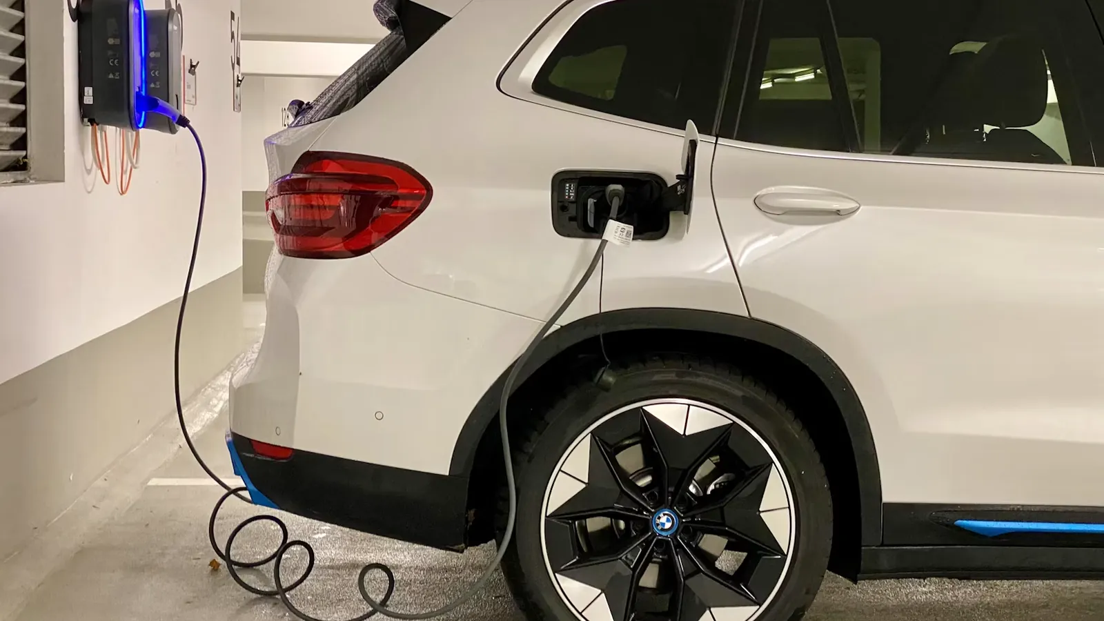 Electric vehicle plugged into a charging station in an underground garage