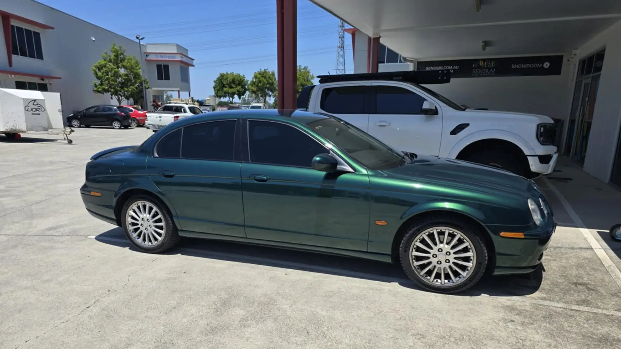 Green Jaguar luxury sedan with tinted windows finished by GTS car window tinting specialists