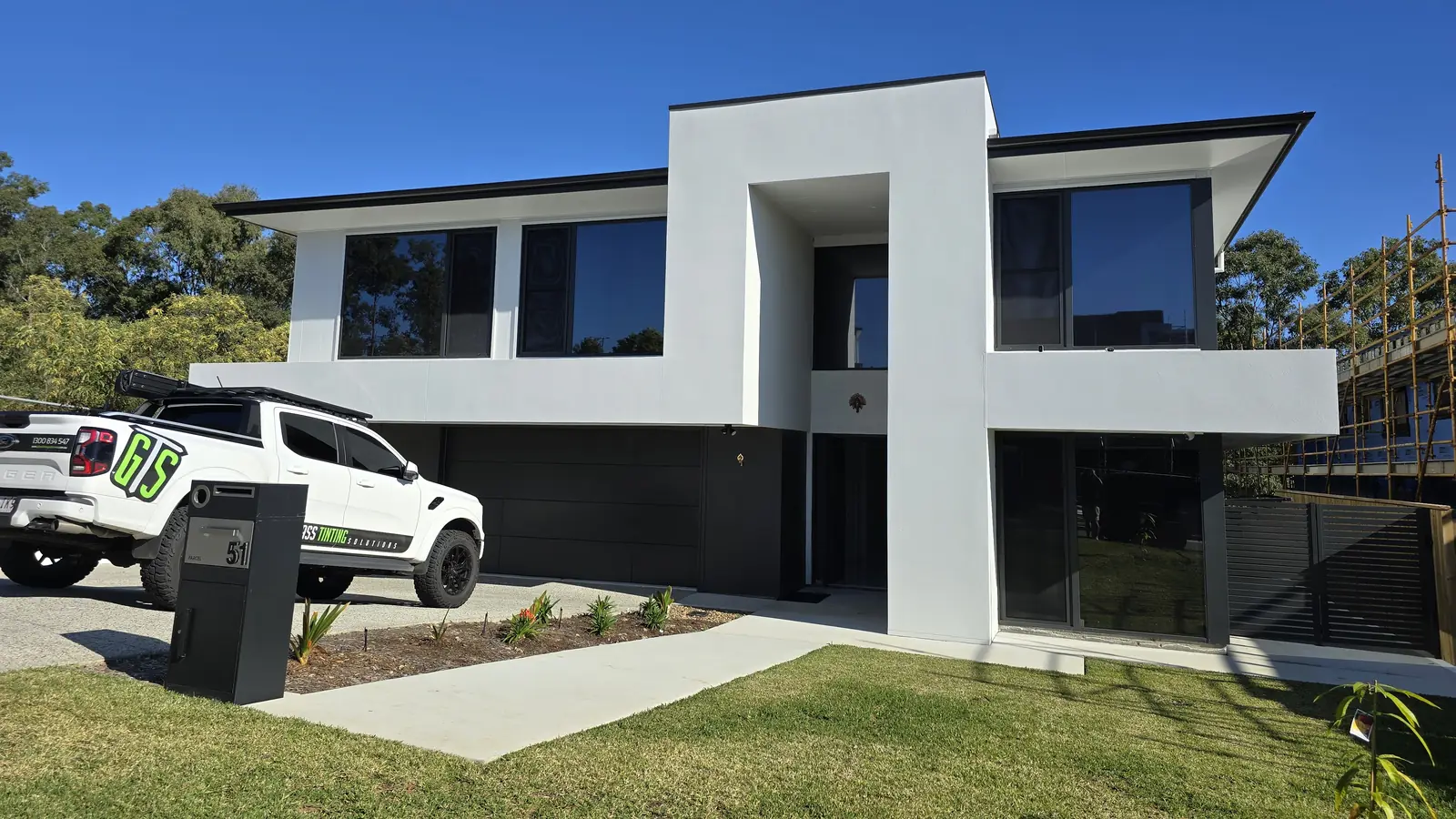 Modern double storey home with dark residential window tinting installed by GTS, with the GTS work ute parked in the driveway
