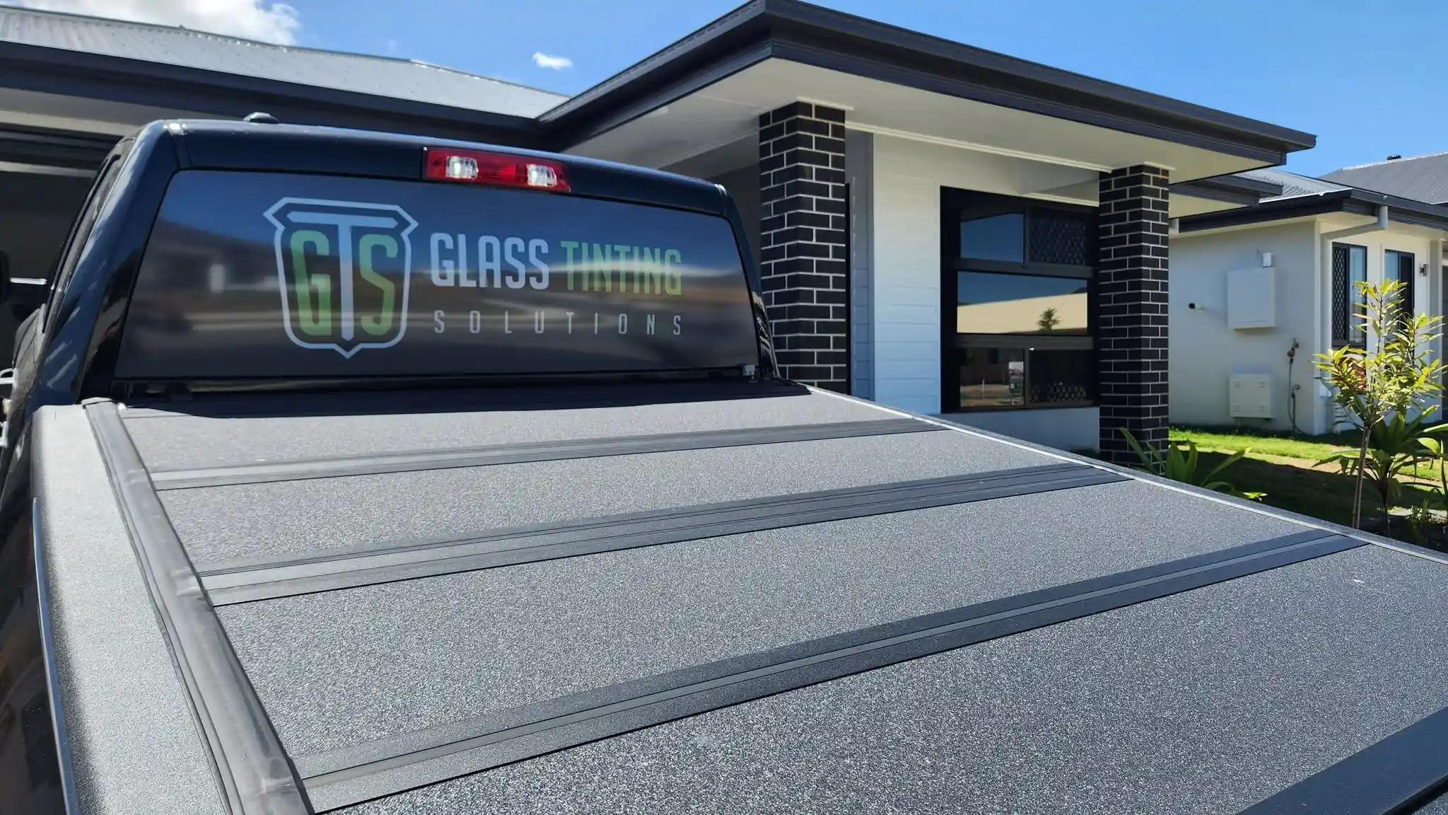 Glass Tinting Solutions service vehicle outside a residential property for home window tinting installation.